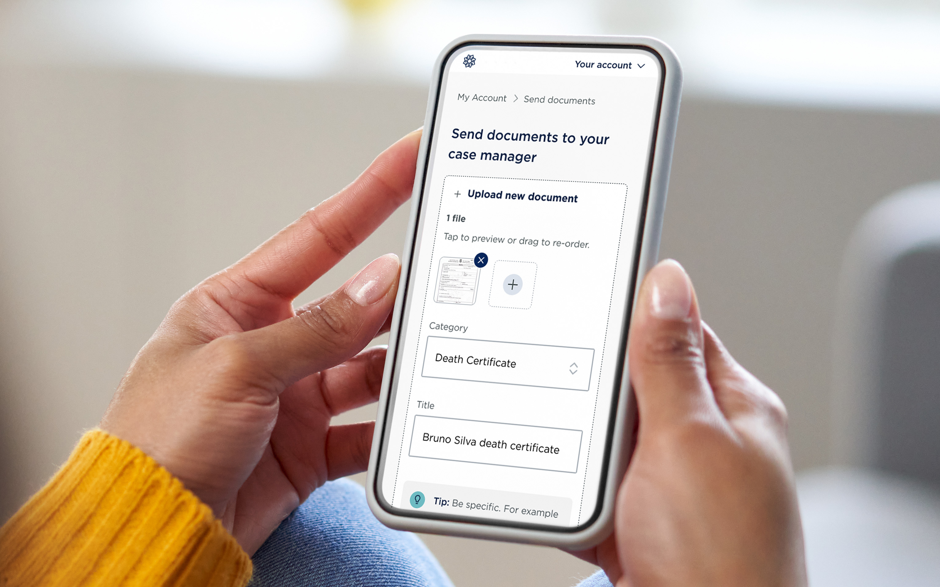 Hands holding a phone showing an online form for sending documents such as a death certificate.