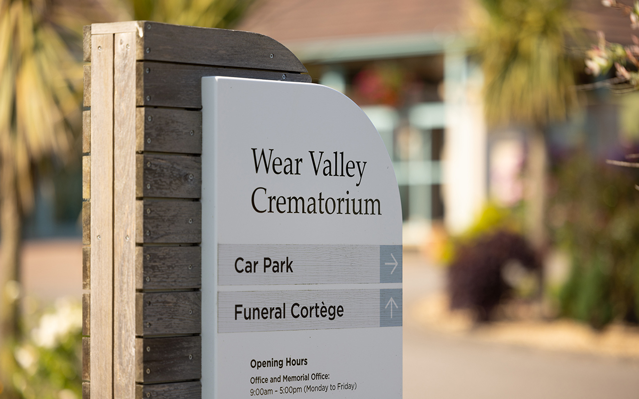 A stone entrance sign reading Wear Valley Crematorium, with directions to the car park.